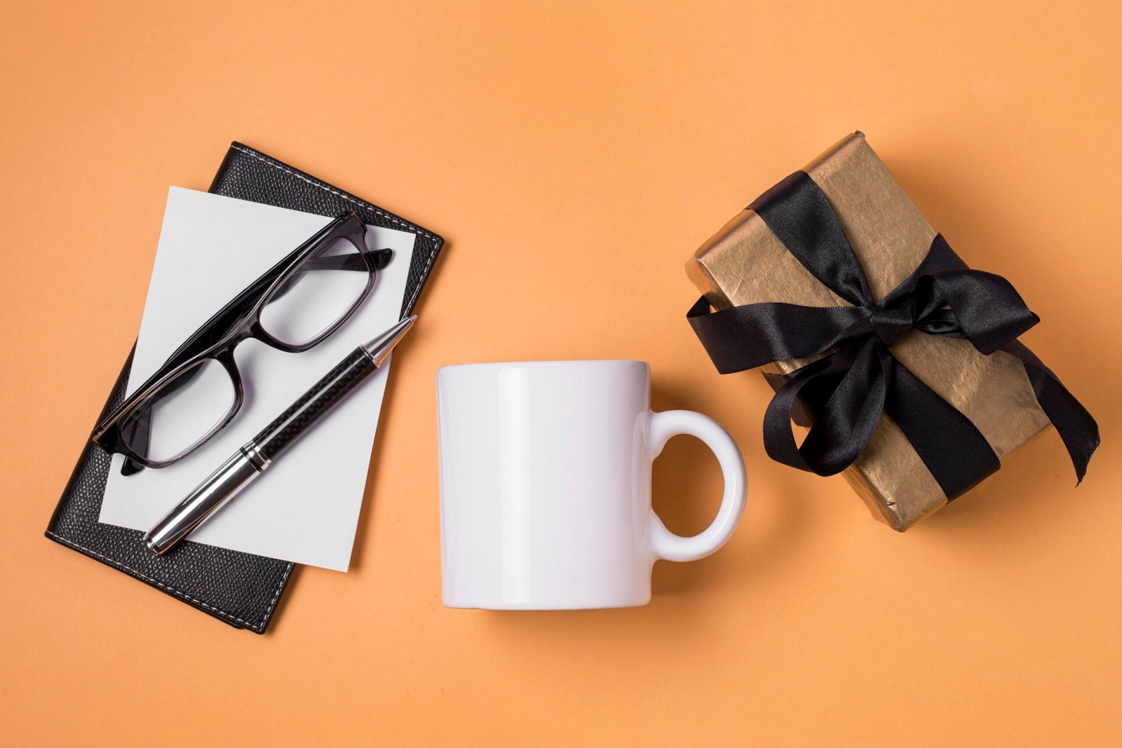 A curated selection of Boss's Day gifts featuring orange-themed items, including a personalized leather wallet, a stylish tie, gourmet chocolates, and a vibrant floral arrangement, all presented in a sophisticated gift box.